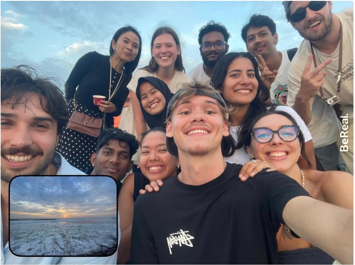 The cohort crowding into a BeReal on the beach at sunset
