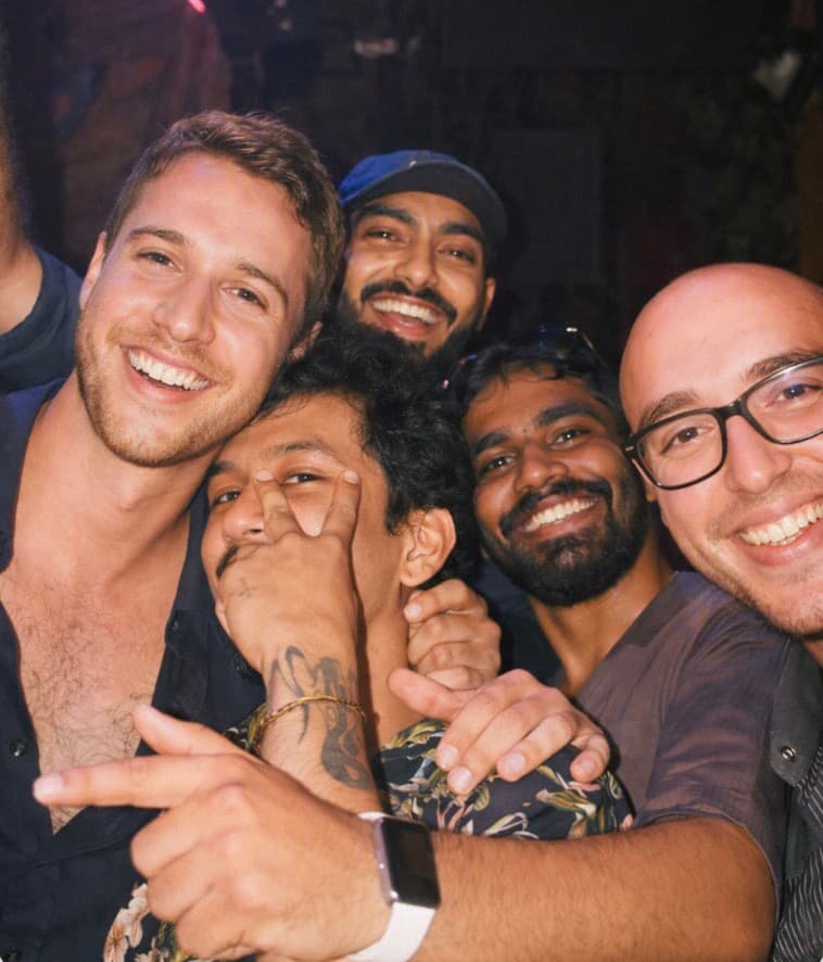 Five interns with their arms around each other, laughing on a night out in Bali